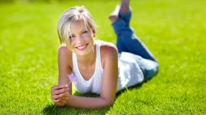 Blonde girl, grass, flower, smile wallpaper thumb