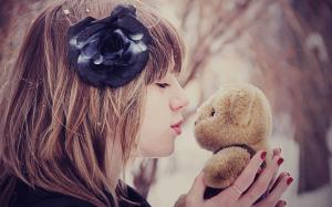 Girl kissing a teddy bear out in the snow wallpaper thumb