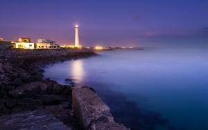 Lit Lighthouse At A Night Seashore wallpaper thumb