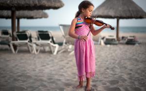 Cute little girl at the beach playing a violin wallpaper thumb