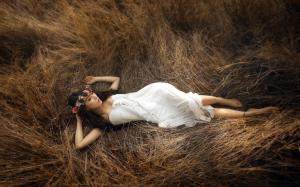 White dress girl lying in hay wallpaper thumb