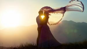 Young married kissing at sunset wallpaper thumb