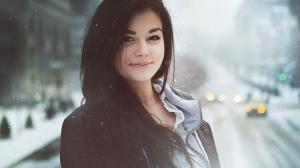 Smiling brunette covered in snowflakes wallpaper thumb