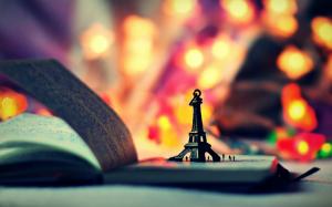 Eiffel Tower model, book, colorful lights wallpaper thumb