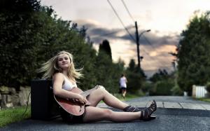 Music-loving girl, sitting on the side of the road, play the guitar wallpaper thumb